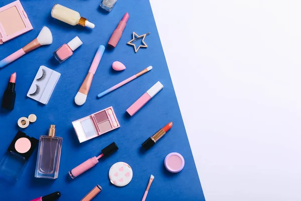 Conjunto de cosméticos decorativos profesionales, herramientas de maquillaje y accesorios sobre fondo azul. concepto de belleza, moda y compras. composición laica plana, vista superior — Foto de Stock