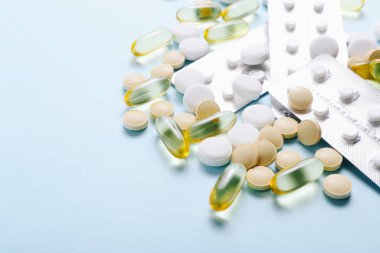 Çeşitli ilaç ilaçları vitaminler, haplar, mavi arka planda uyuşturucular.