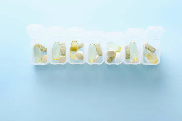 Открыть ежедневно таблетки поле на синем фоне . — стоковое фото