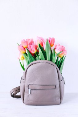 School bag with pink tulip flowers. Back to school fashion concept.