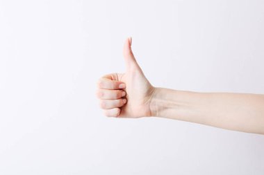 Female hand making gesture like thumb up of right on white background.