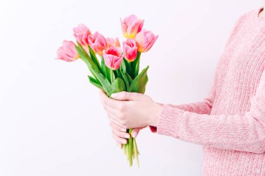 Woman holding a spring bouquet of pink tulips in her hands. Bunch of fresh tulip flowers in female hands