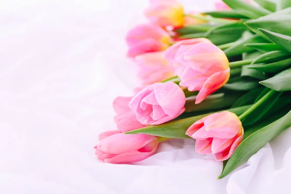 Bouquet of pink tulips on white bed. — Stock Fotó