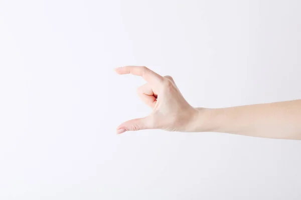 Mão feminina vazia fazendo gesto como segurar algo no fundo branco . — Fotografia de Stock
