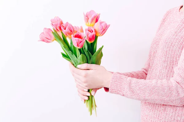 Woman holding a spring bouquet of pink tulips in her hands. Bunch of fresh tulip flowers in female hands