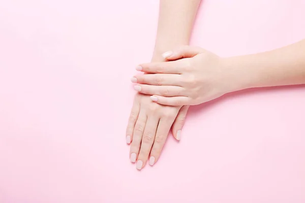 Mãos de mulheres com a bela manicura no fundo rosa. Conceito de spa de mãos — Fotografia de Stock