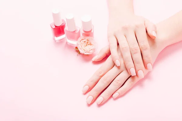 Mujeres manos con hermosa manicura sobre fondo rosa. Manos concepto de spa — Foto de Stock