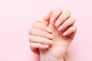 Beautiful woman manicure on creative trendy pink background. Minimalist manicure trend. Top view, flat lay. Copy space for your text.