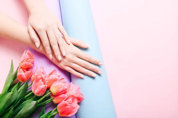 Hermosa manicura de mujer sobre fondo rosa de moda creativa. Tendencia minimalista de manicura. Vista superior, cama plana. Copia espacio para tu texto . — Foto de Stock