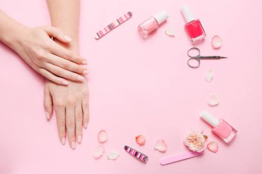 Different tools for manicure on pink background, top view