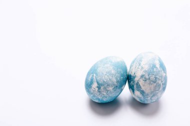 Beyaz zemin üzerinde mavi mermer taş efektli iki şık yumurta.