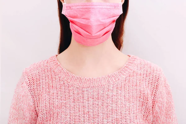 Jovem mulher vestindo máscara médica no fundo de luz, close-up — Fotografia de Stock