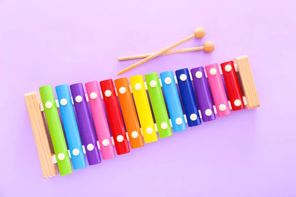 Szivárvány színű fa játék xilofon két rúd lila háttér. Felülnézet — Stock Fotó