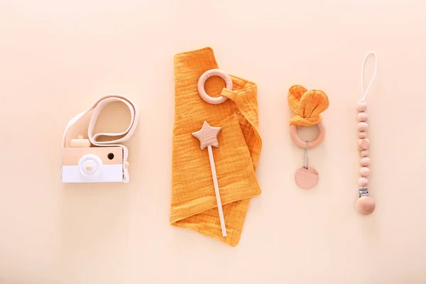 Baby accessories: wooden toys, beanbag and teethers on light background. Top view, flat lay. — Stock Photo, Image