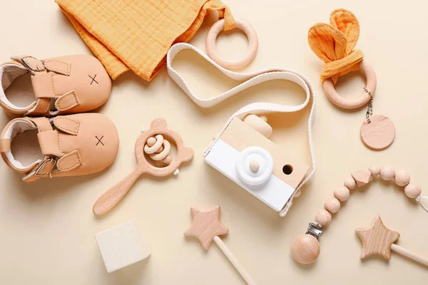 Conjunto de zapatos de bebé, juguetes y accesorios sobre fondo beige. Cosas de moda para recién nacidos. Piso tendido, vista superior — Foto de Stock