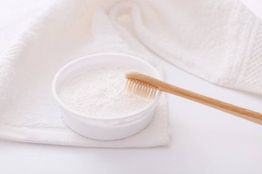 Tahta diş fırçası ve beyaz havlunun üzerindeki diş pudrası. Sıfır atık