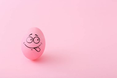 Pembe arka planda yüzü olan komik pembe yumurta.