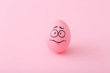 Renkli arka planda yüzü olan komik pembe yumurtalar.