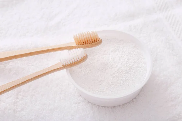 Wooden teeth brushes and tooth-powder on white towel backgroud. Zero waste concept — Stock Photo, Image