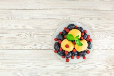 meyve ve böğürtlen bir tabak üzerinde ahşap bir arka plan fotokopi alanı