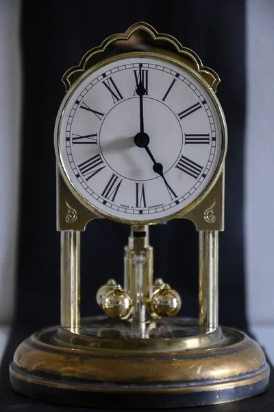 Saat 5: 00 'te, sarkaçlı antika bir masa saati.