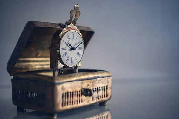 Eski sarkacı olan antika pirinç kutu.