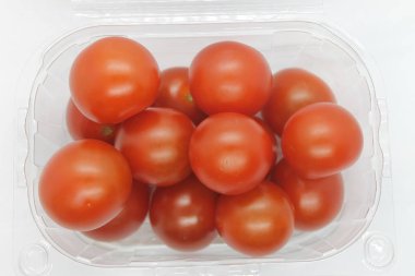 Arka planda küçük kırmızı domatesler var..