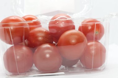 Arka planda küçük kırmızı domatesler var..