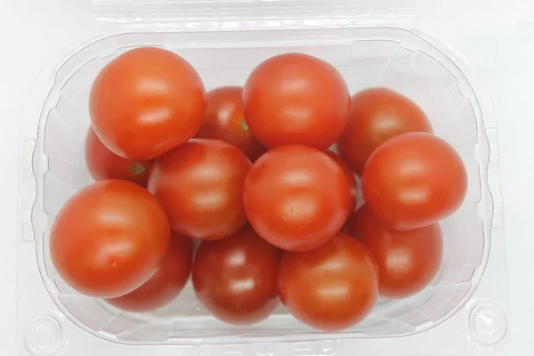 Arka planda küçük kırmızı domatesler var..