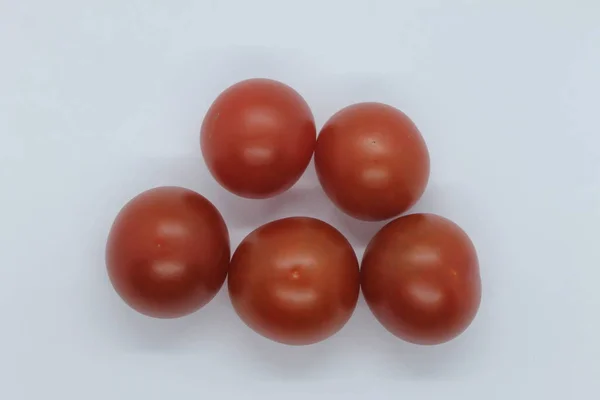 Arka planda küçük kırmızı domatesler var..