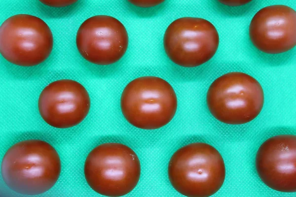 Arka planda küçük kırmızı domatesler var..