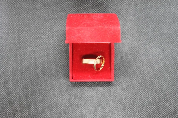 Düğün için kırmızı bir kutuda altın yüzükler..