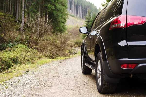 Velká černá Suv v zasněženém zimním lese — Stock fotografie