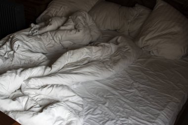 Bir otel odasında yapılmamış yatak. Sabahın erken saatlerinde, pencerelerden gelen ışık. Bir otel odasında yapılmamış yatak. Sabah erkenden, gölge..