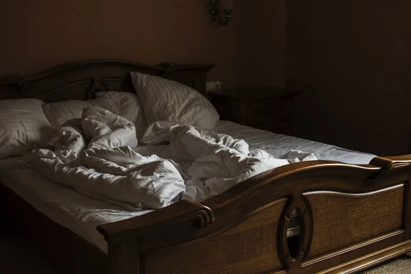 Bir otel odasında yapılmamış yatak. Sabahın erken saatlerinde, pencerelerden gelen ışık. Bir otel odasında yapılmamış yatak. Sabah erkenden, gölge..