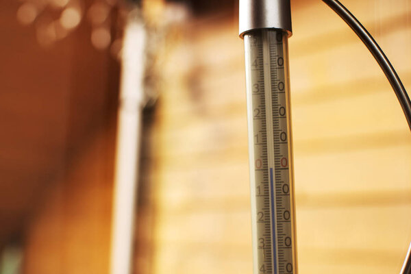 A thermometer, fixed out of the window, shows that it is zero degree celsius outdoor, while it is warm inside the room
