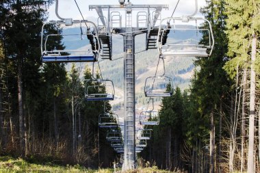 İnsansız asansör. Mavi gökyüzündeki teleferik. Dağlarda insanların olmadığı bir yol.