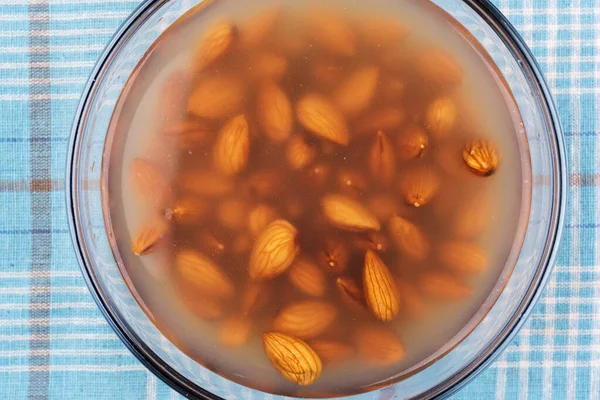 Almonds left to rest water to swell — Stockfoto