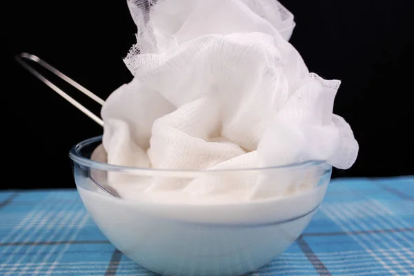 Preparación de almendras veganas o leche de coco en casa. Verter la leche en un paño de queso para filtrarla . —  Fotos de Stock