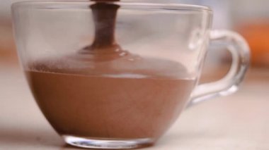 Yumuşak, lezzetli eritilmiş siyah ya da sütlü çikolatayı beyaz bir kaba dök. Yakın çekim..