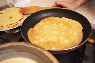 Sıcak tavada krep pişirme süreci.