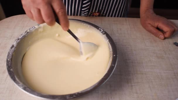 Процесс приготовления и взбивания теста, женская рука смешивает жидкое тесто с венчиком в миске . — стоковое видео