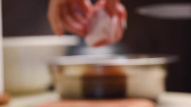 Bir aşçının elleri mutfak bıçağıyla tendonu domuz etinden ayırır.