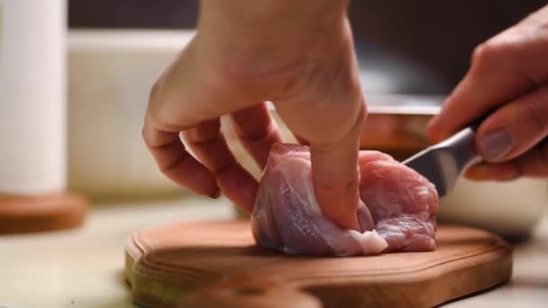 Kobiece dłonie kucharza nożem kuchennym oddzielają ścięgno od mięsa wieprzowego — Wideo stockowe