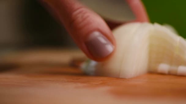 Rebanadas la cebolla. Cuchillo, cortando cebolla. Mitad de aros de cebolla. Las manos del cocinero. Corten hortalizas para la ensalada. Comida saludable. Primer plano . — Vídeo de stock