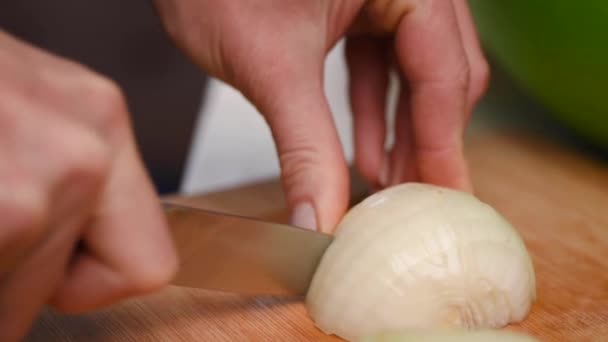 Rebanadas la cebolla. Cuchillo, cortando cebolla. Mitad de aros de cebolla. Las manos del cocinero. Corten hortalizas para la ensalada. Comida saludable. Primer plano . — Vídeos de Stock