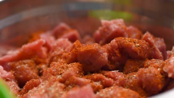 Sprinkling black pepper to raw meat piece on wooden board slow motion. — Stock Video