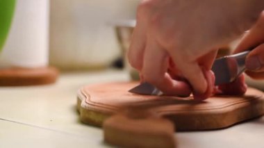 Bir aşçının elleri mutfak bıçağıyla tendonu domuz etinden ayırır.