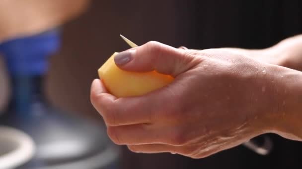Manos femeninas pelando patatas con cuchillo — Vídeo de stock