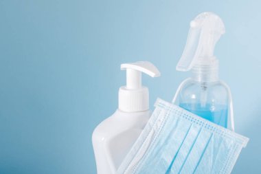 Koronavirüse karşı korunma sembolleri. Tıbbi maske ve antiseptik dezenfektan spreyi. Metin için yeri boş. Dezenfektan şişesi ve koruyucu maske yakın plan. Hijyen kavramı, kopyalama alanı